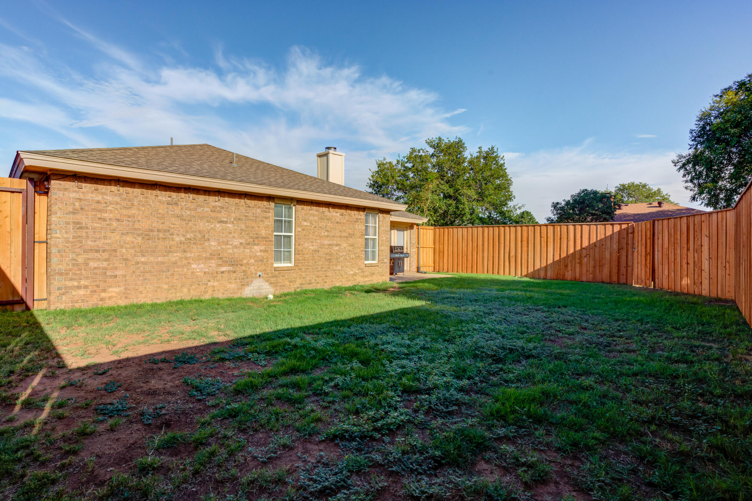 8406 Canton Avenue Lubbock, TX 79423 - Photo 22 of 25 a backyard view with large trees and plants