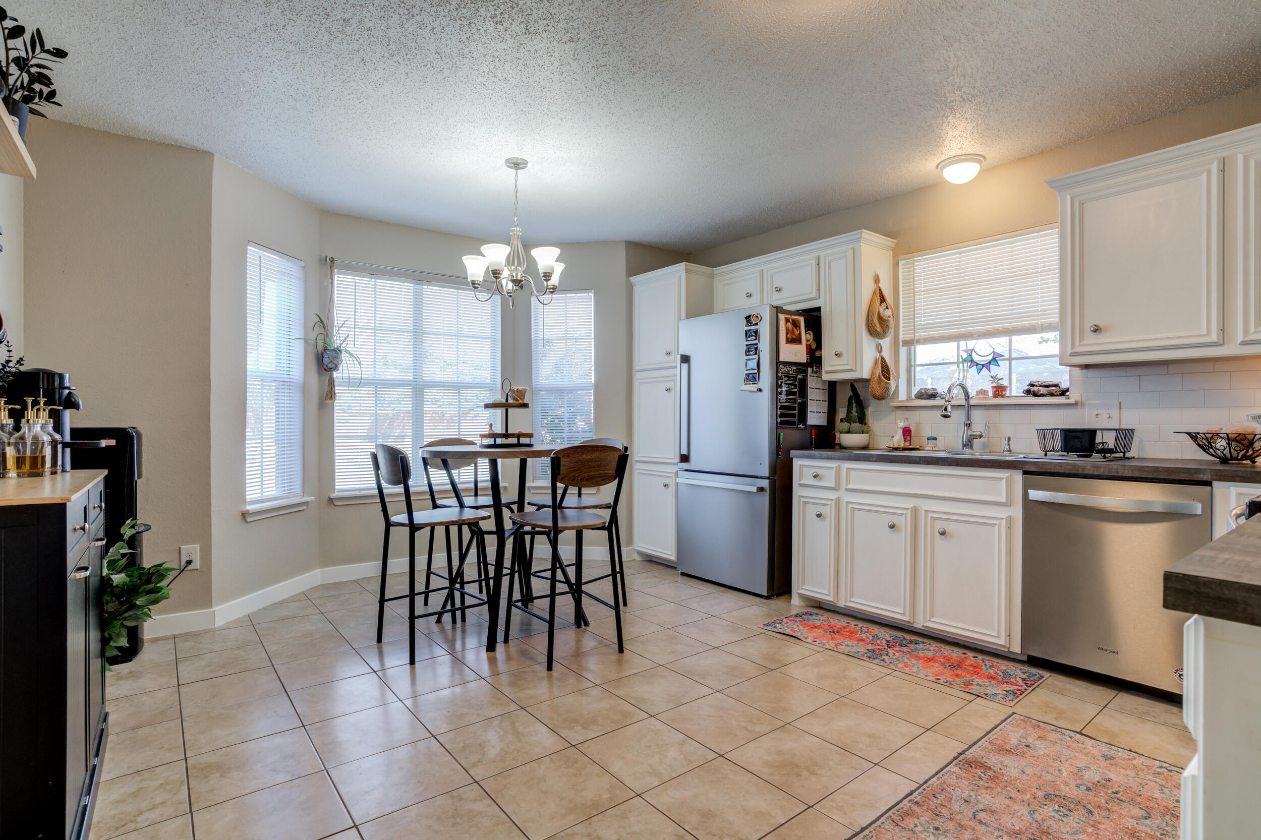 8406 Canton Avenue Lubbock, TX 79423 - Photo 3 of 25 a kitchen with stainless steel appliances a dining table chairs a refrigerator and cabinets