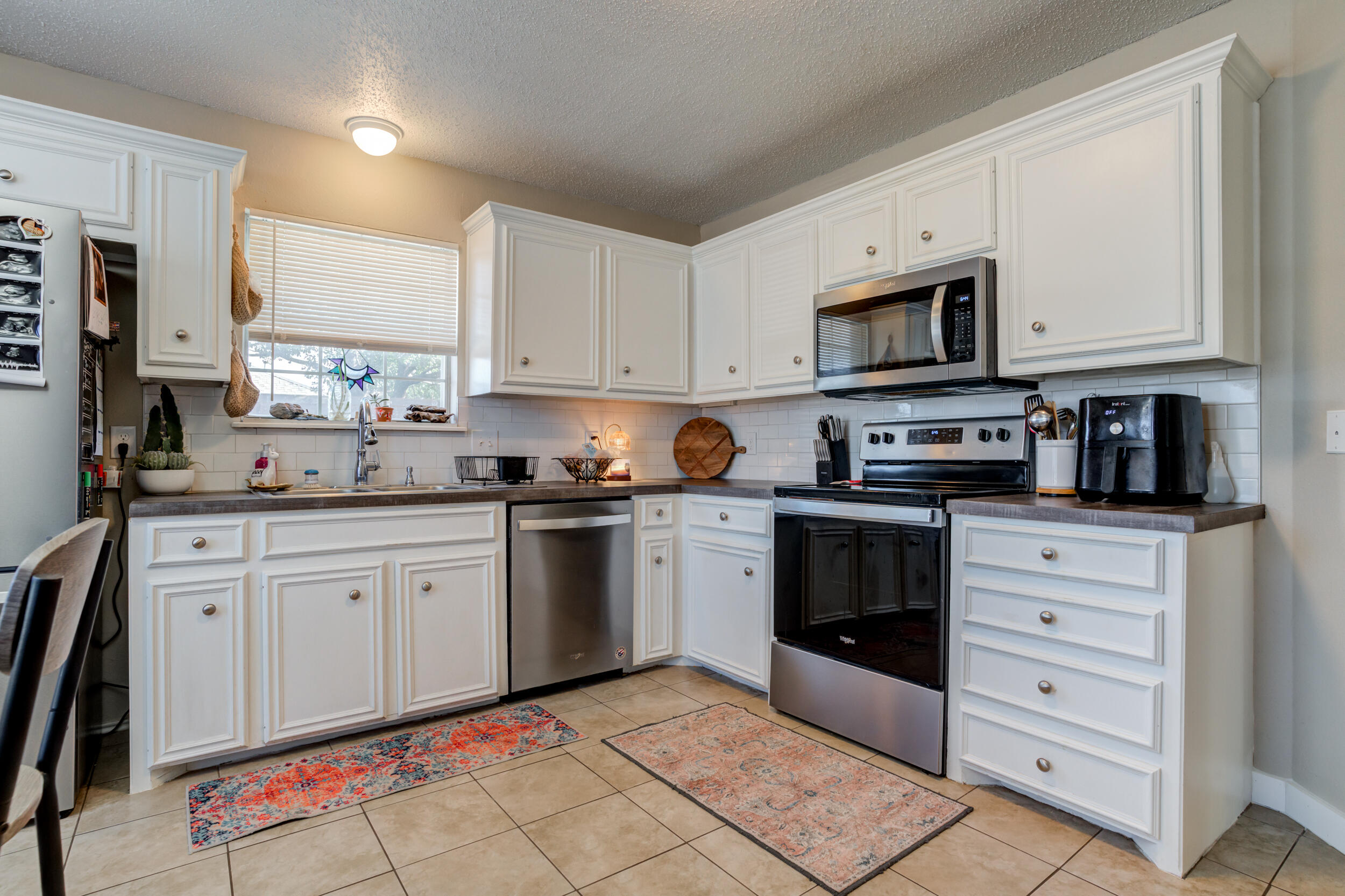 8406 Canton Avenue Lubbock, TX 79423 - Photo 4 of 25 a kitchen with stainless steel appliances granite countertop a stove a sink and a refrigerator