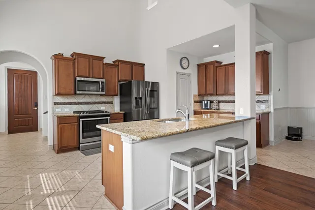 a kitchen with stainless steel appliances granite countertop a white cabinets and a stove top oven