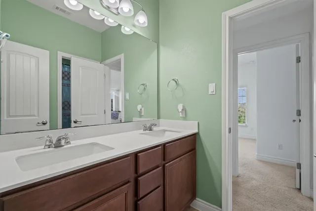 a bathroom with a sink double vanity granite and a mirror