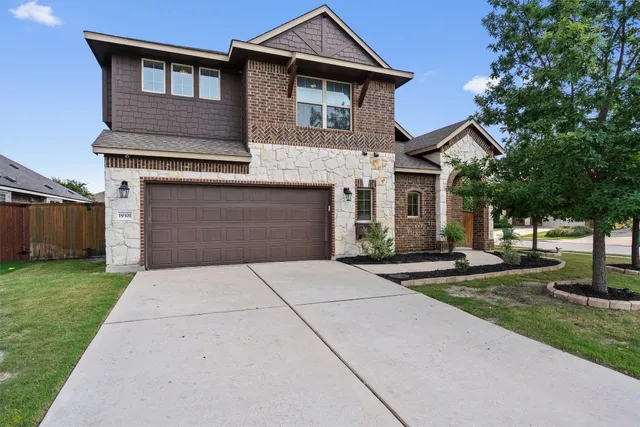 a front view of a house with a garden and trees