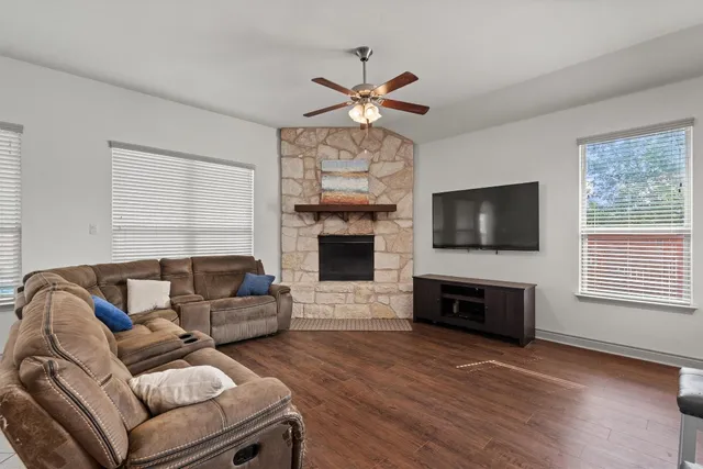 a living room with furniture a flat screen tv and a fireplace