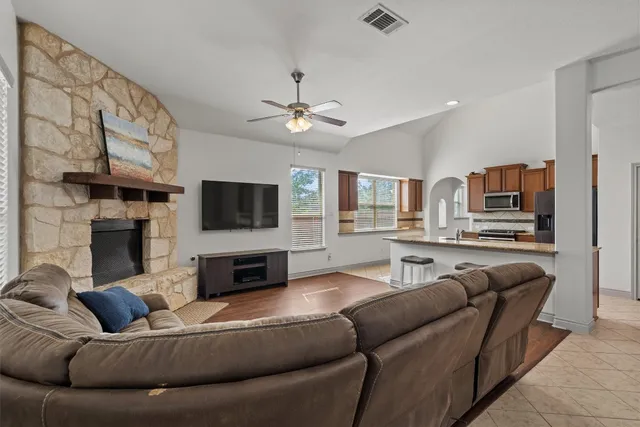 a living room with furniture a flat screen tv and a fireplace