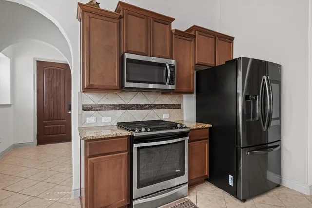 a kitchen with stainless steel appliances granite countertop a refrigerator stove and microwave