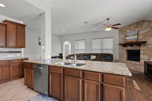 a kitchen with a sink dishwasher a stove and a refrigerator with wooden floor