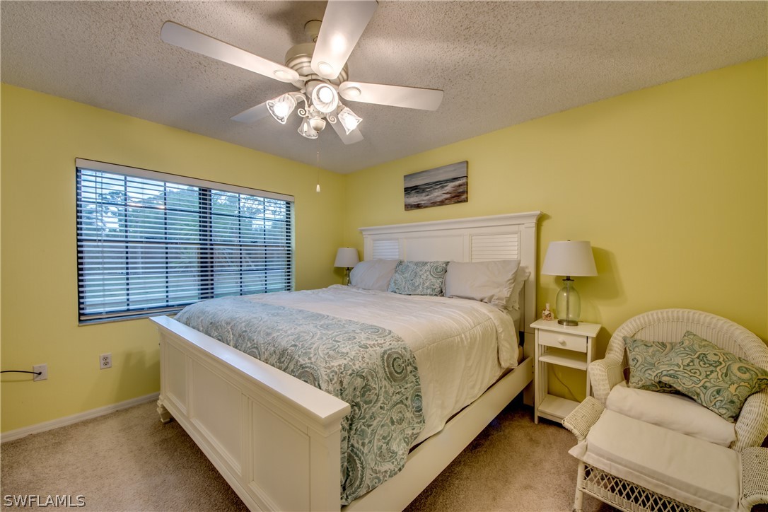 23465 Harbor View Road, Unit 1008 Port Charlotte, FL 33980 - Photo 14 of 33 a spacious bedroom with a bed and a chandelier