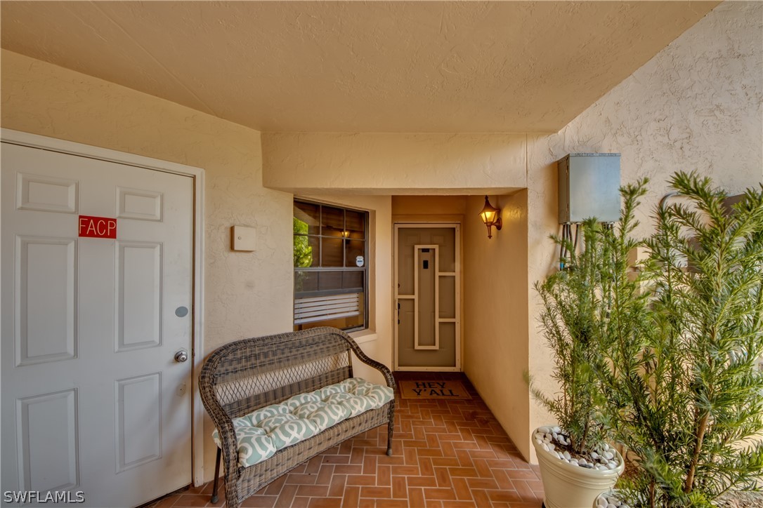 23465 Harbor View Road, Unit 1008 Port Charlotte, FL 33980 - Photo 2 of 33 a view of a hallway with wooden floor and a potted plant