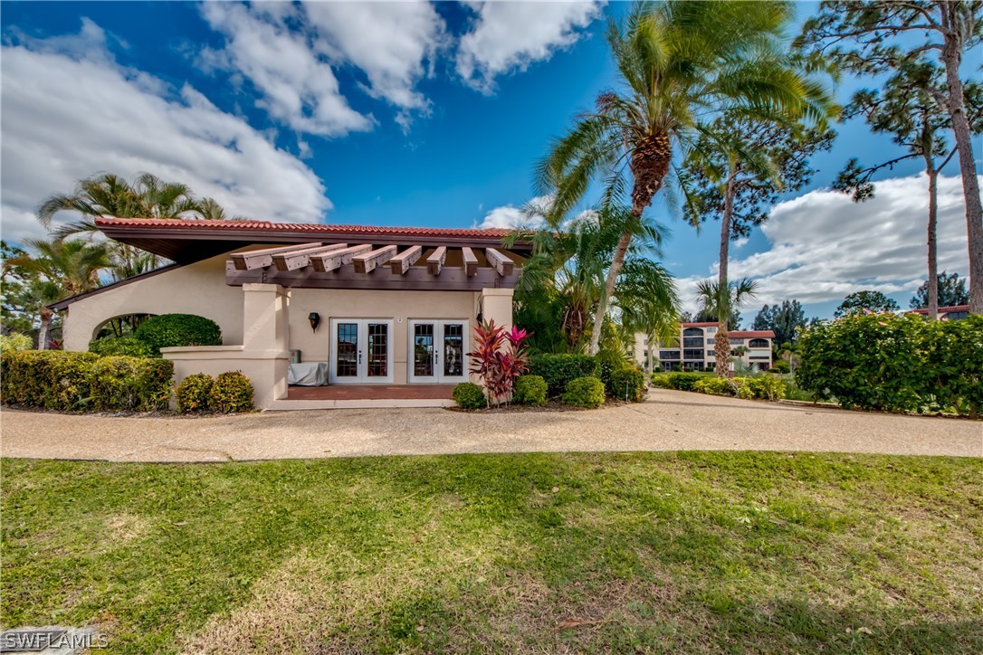 23465 Harbor View Road, Unit 1008 Port Charlotte, FL 33980 - Photo 24 of 33 a front view of a house with a yard and potted plants