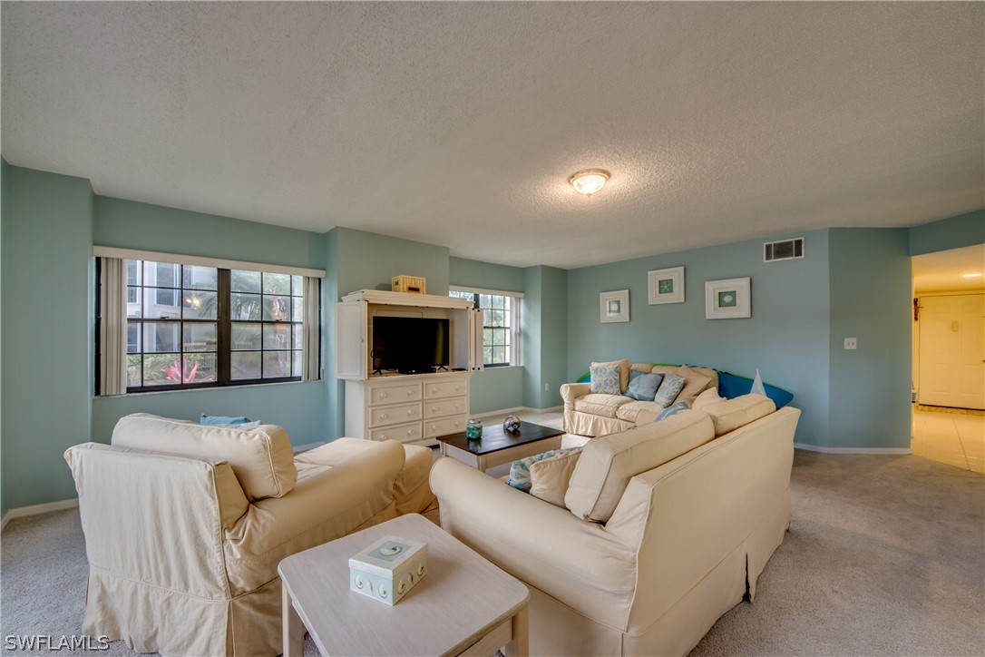 23465 Harbor View Road, Unit 1008 Port Charlotte, FL 33980 - Photo 7 of 33 a living room with furniture and a flat screen tv