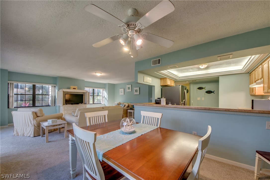 23465 Harbor View Road, Unit 1008 Port Charlotte, FL 33980 - Photo 10 of 33 a living room with furniture a flat screen tv and kitchen view