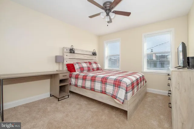 a bedroom with a bed and large windows