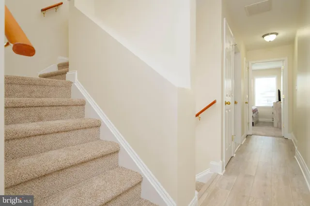 a view of a hallway with wooden floor and staircase