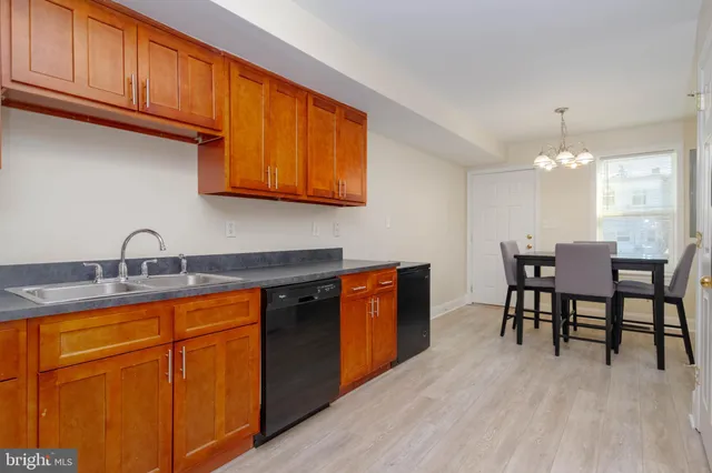 a kitchen with granite countertop a sink cabinets and stainless steel appliances