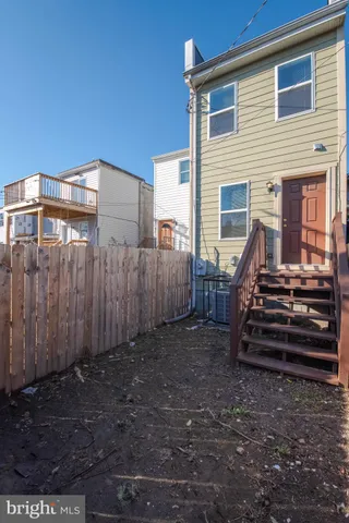 a view of a house with backyard and wooden fence