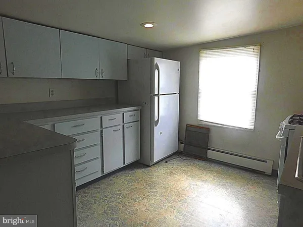 a kitchen with window and refrigerator