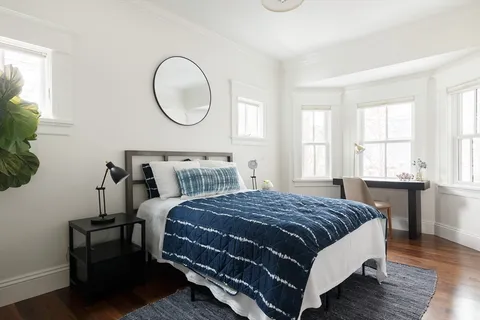 a bedroom with a bed lamp and a window
