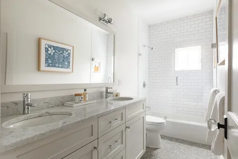 a bathroom with a granite countertop sink toilet tub and shower