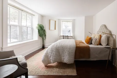 a bedroom with a bed and wooden floor