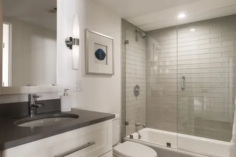 a bathroom with a granite countertop sink a toilet and shower