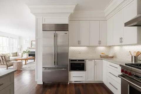 a kitchen with a refrigerator stove and white cabinets