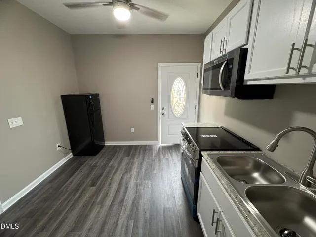 a kitchen with a sink a stove and cabinets