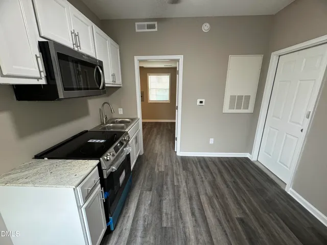 a kitchen with a stove microwave and a sink