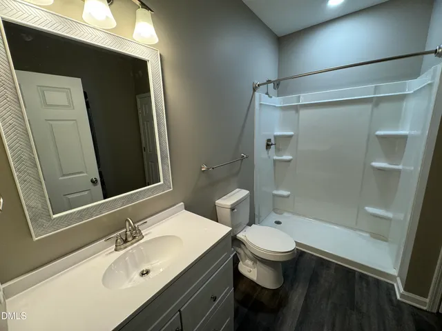 a bathroom with a sink a toilet and shower
