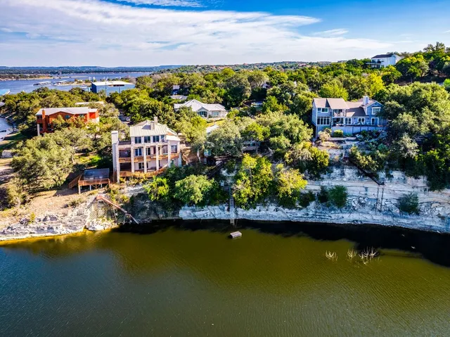 a view of a lake with boats and trees all around