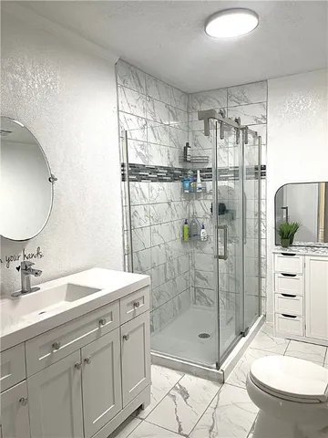 a bathroom with a shower sink and mirror