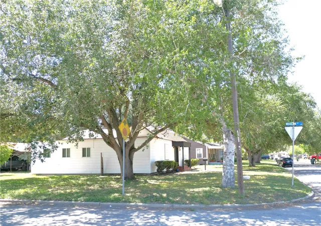 a tree in front of a white house