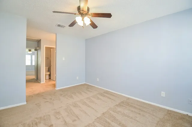 an empty room with fan and entrance