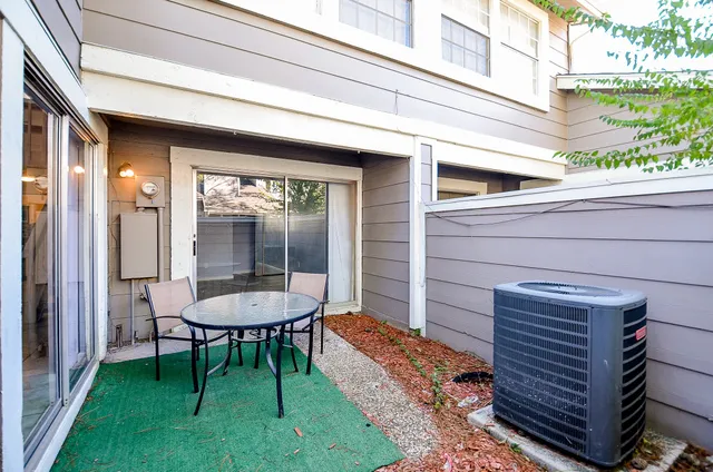 a view of a chair and table in backyard of the house