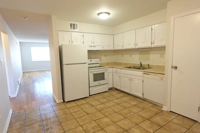 a kitchen with white cabinets and white appliances