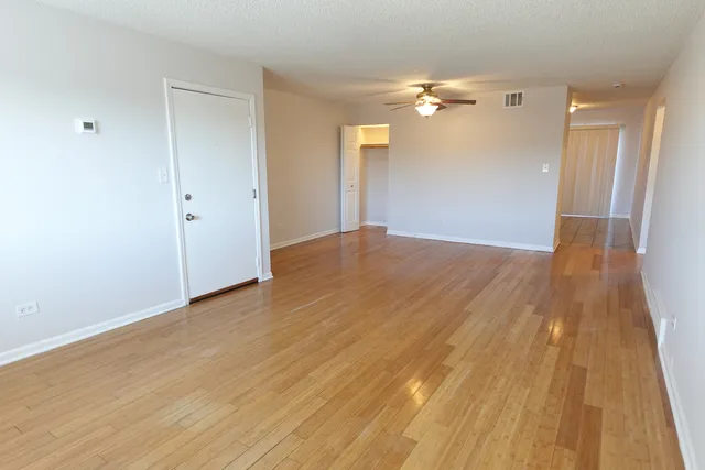a view of empty room with wooden floor
