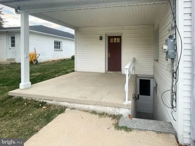 a view of a white house with a yard and plants