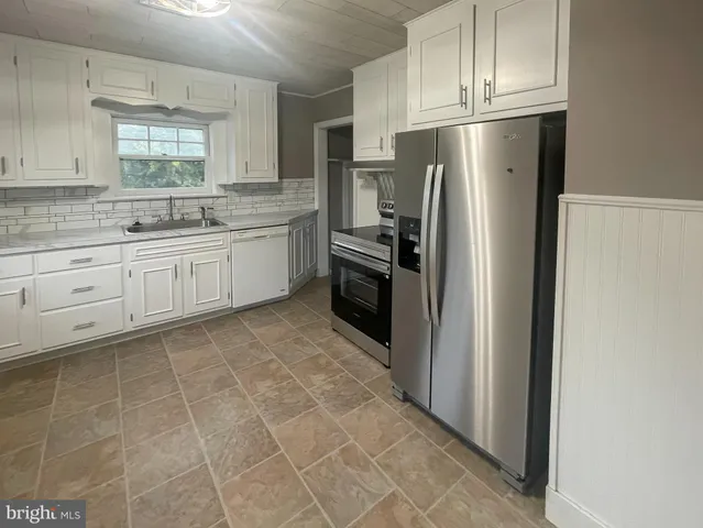 a kitchen with stainless steel appliances granite countertop a refrigerator sink and cabinets
