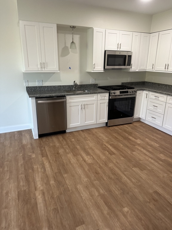 a kitchen with stainless steel appliances granite countertop a stove a sink and a microwave