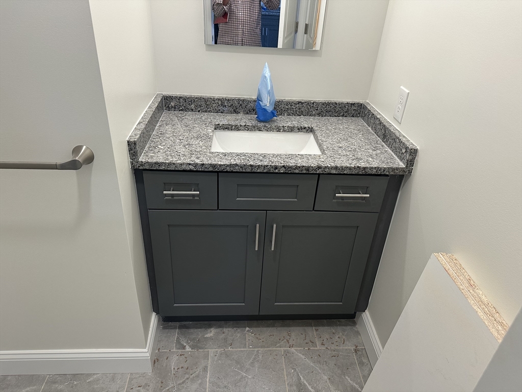 10 Franklin Avenue, Unit 403 Revere, MA 02151 - Photo 13 of 13 a bathroom with a granite countertop sink and a mirror