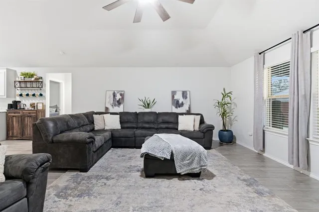 a spacious bedroom with a bed a couch and a chandelier