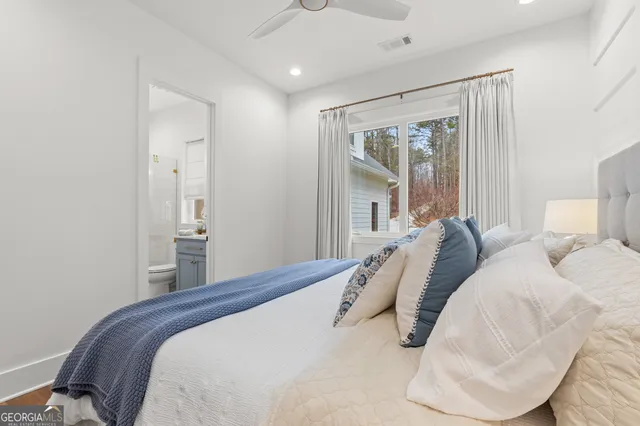 a bedroom with a bed and a lamp on dresser