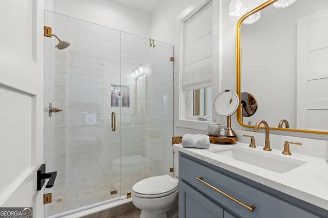 a bathroom with a toilet a sink and mirror