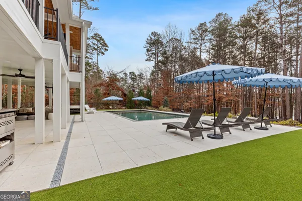 a view of a house with backyard and sitting area