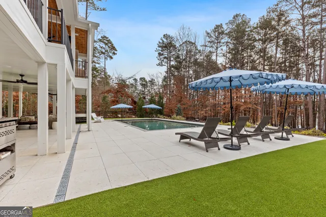 a view of a house with backyard sitting area and swimming pool