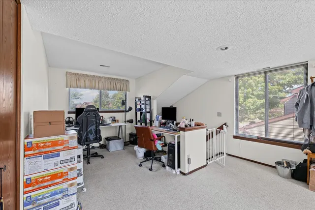 a view of a workspace with furniture and a window