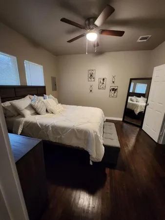 a bedroom with a bed and wooden floor