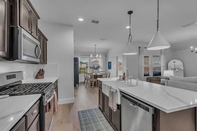 a kitchen with sink stove and cabinets