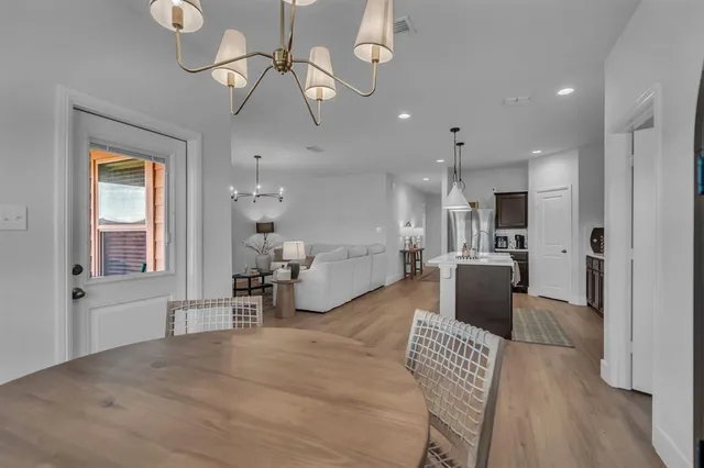 a living room with furniture a chandelier and a dining room