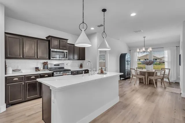 a kitchen with sink stove and cabinets