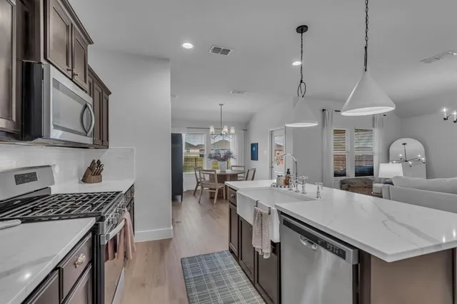 a view of a dining room with furniture a chandelier and wooden floor